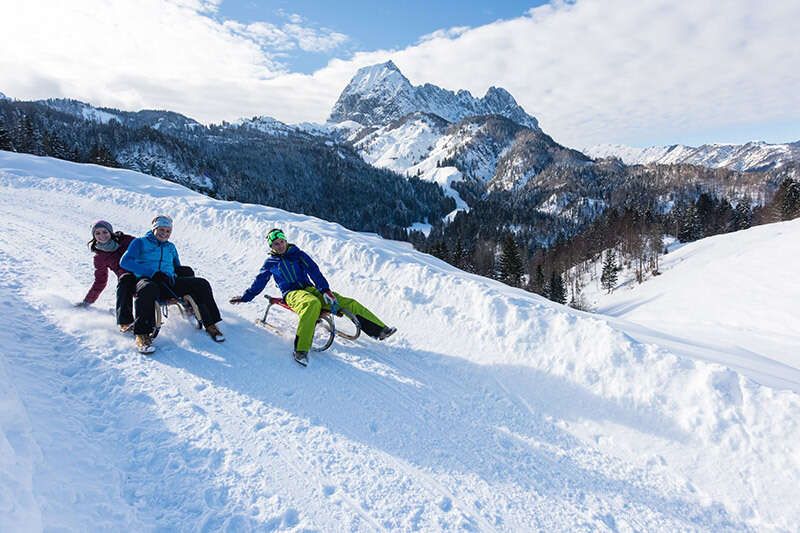 Rodeln in der Region St Johann in Tirol vor dem Wilden Kaiser